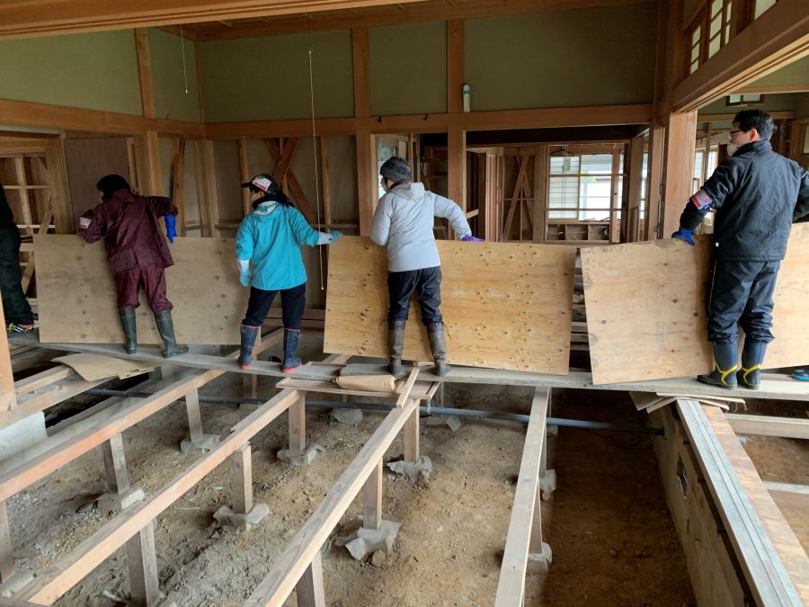 浸水した建物の床と壁を剥がし、床下の泥出しをする支援に